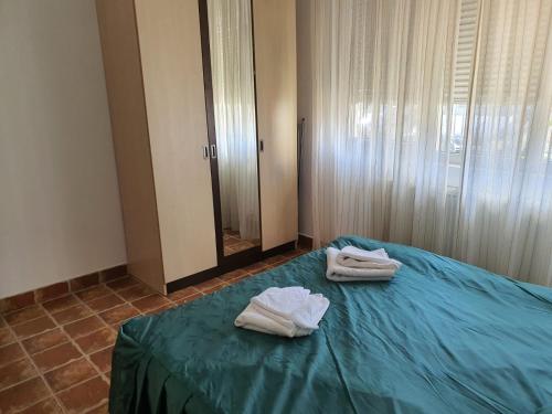 ein Schlafzimmer mit 2 Handtüchern auf einem Bett mit Spiegel in der Unterkunft Club Cristal Apartments in Neptun