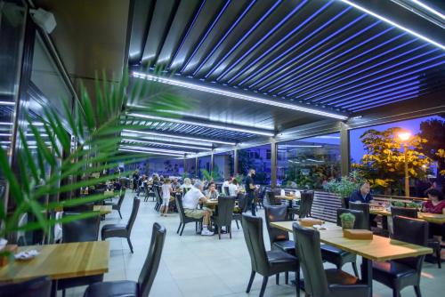 
a restaurant with tables, chairs, and tables with umbrellas at Hotel Tomis in Mamaia
