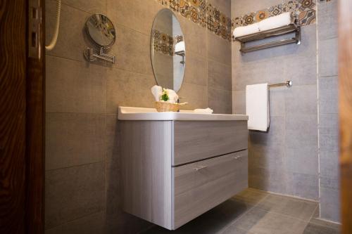 a bathroom with a sink and a mirror at Holy Family Hotel in Jabal aţ Ţayr