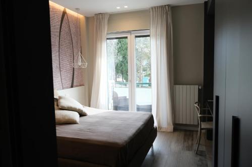 a bedroom with a bed and a large window at Garibaldi House - B&B Luxury in Acquaviva delle Fonti