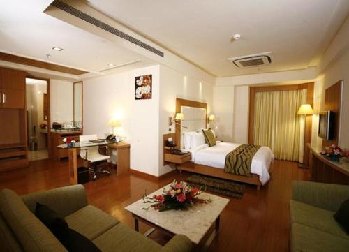 Habitación de hotel con cama y escritorio en Ambrosia Sarovar Portico, en Haridwar