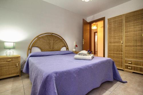 a bedroom with a large bed with a purple blanket at Villetta Daniela Fronte Spiaggia in Marina di Pescoluse