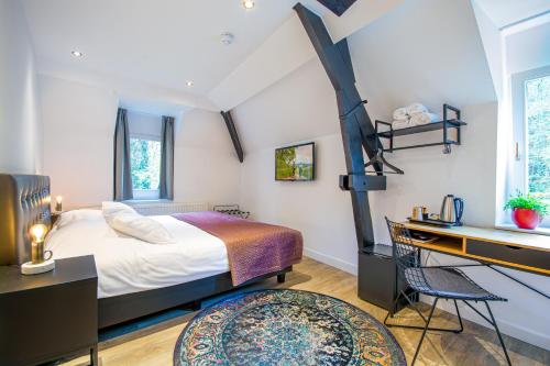 sypialnia z dużym łóżkiem, biurkiem i biurkiem w obiekcie Landgoed Overste Hof w mieście Landgraaf