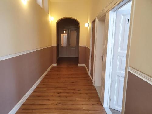 an empty hallway with a wooden floor and a door at Ferienwohnungen am Stadtpark in Norden