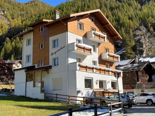 un edificio in montagna con macchine parcheggiate di fronte di Bergröschen a Saas-Grund