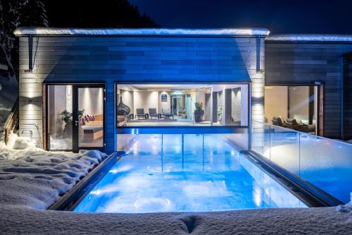 a swimming pool in the middle of a house at Das Kaltenbach - ApartHotel in Kaltenbach