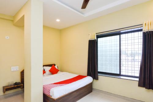 a bedroom with a bed and a large window at Sukrangu Palace in Shirdi