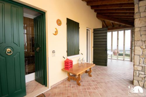 a room with green doors and a wooden table at Villa Jole in Polpenazze del Garda