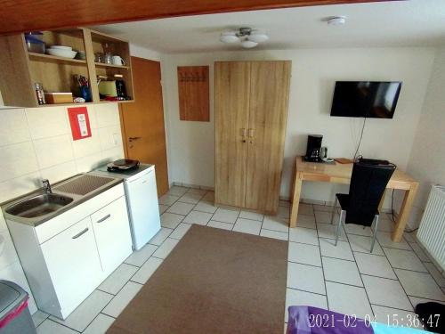 a small kitchen with a sink and a table at Ferienzimmer Gersprenztal in Reichelsheim