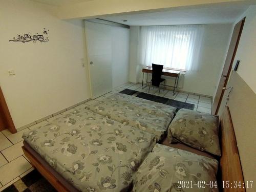 a bedroom with two beds in it with a desk at Ferienwohnung Gersprenztal in Reichelsheim