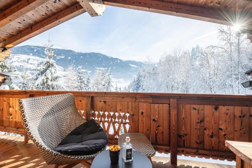 a porch with a chair and a table with a view at Das Kaltenbach - ApartHotel in Kaltenbach