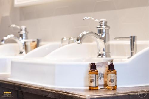 a bathroom sink with two bottles of essential oils on a counter at Château d'Hermival in Hermival-les-Vaux