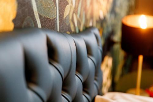 a row of black leather chairs next to a lamp at Deville & Spa in Costermano sul Garda