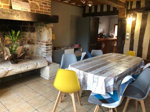 une salle à manger avec une table et des chaises dans l'établissement L'étable aux Gîtes du val, à Genneville