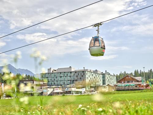 a cable car flying over a green field at Arena Franz Ferdinand Nassfeld in Tröpolach
