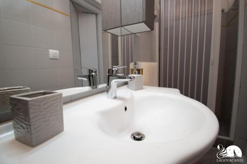 ein Badezimmer mit einem weißen Waschbecken und einem Spiegel in der Unterkunft Appartamenti Caterina in Montinelle