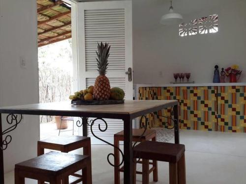 un tavolo con un ananas sopra in una cucina di Chalé Gostosomar a São Miguel do Gostoso