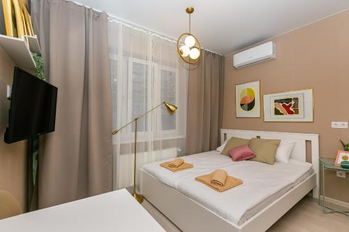 1 dormitorio con 1 cama con 2 toallas en ARRIVAL- Новые дизайнерские апартаменты - Экспоград-ЮГ, en Krasnodar