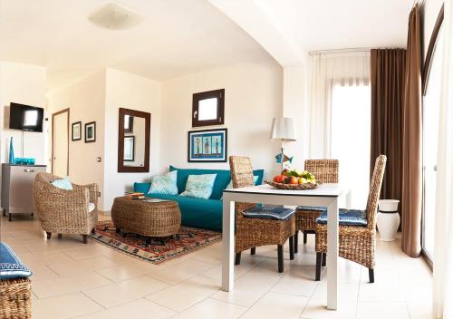 レ・カステッラにあるLe Castella Resort & Beachのリビングルーム(青いソファ、テーブル付)