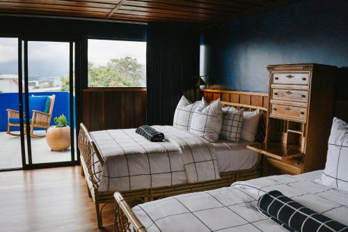 a bedroom with two beds and a balcony at Casa 41 in Escazu