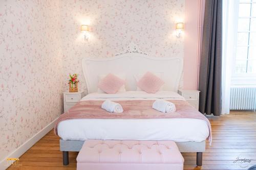 a bedroom with a white bed with pink wallpaper at Château d'Hermival in Hermival-les-Vaux