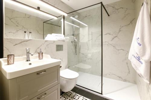 a bathroom with a shower and a sink and a toilet at Apartamenty Royal Maris 1 - najlepsza lokalizacja w Ustce, blisko plaży i portu, bezpłatny parking, ścisłe centrum in Ustka