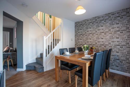 a dining room with a table and chairs and a brick wall at Wilton Lodge in Redcar