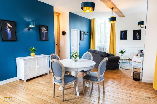 a living room with blue walls and a table and chairs at Château d'Hermival in Hermival-les-Vaux