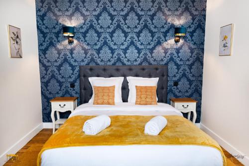 a bedroom with a large bed with blue wallpaper at Château d'Hermival in Hermival-les-Vaux
