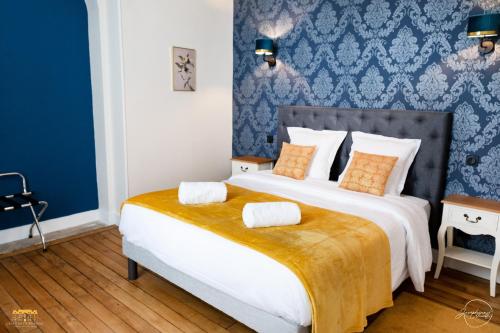 a bedroom with a large bed with a blue wall at Château d'Hermival in Hermival-les-Vaux