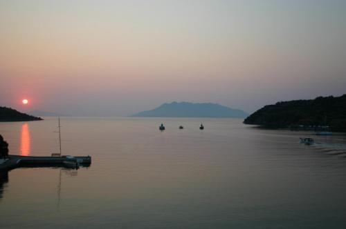 a group of boats on a lake at sunset at Saronis Hotel in Ancient Epidavros
