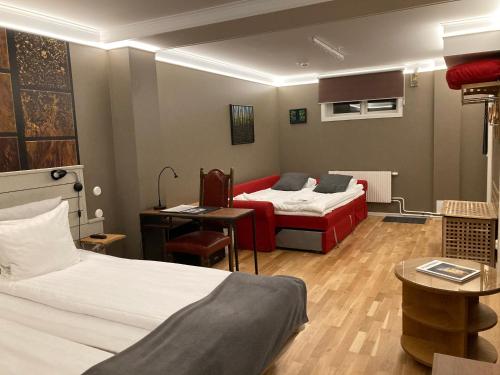 a hotel room with two beds and a desk at Södra Hotellet in Norrköping