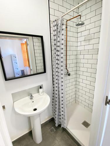 a white bathroom with a sink and a shower at ECO Hostel in Granada