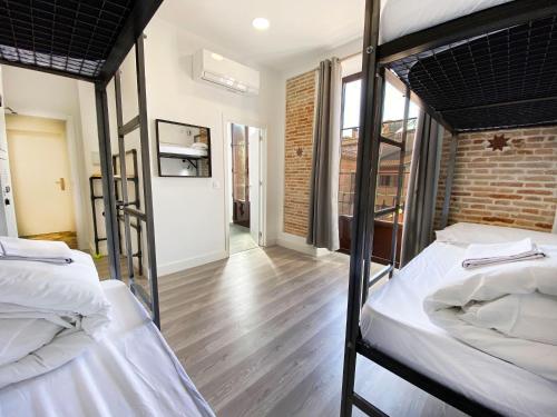 two bunk beds in a room with a hallway at ECO Hostel in Granada