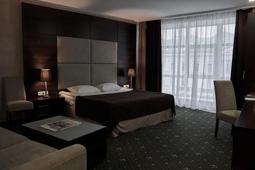 a hotel room with a bed and a couch at Optima Collection Gallery Poltava in Poltava