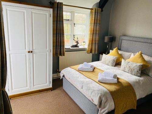a bedroom with a bed and a dresser at The Royal Oak Inn in Withypool