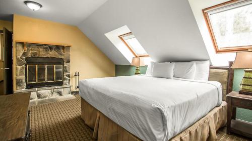 a bedroom with a large bed and a fireplace at Bluegreen Vacations Christmas Mountain Village, an Ascend Resort in Wisconsin Dells