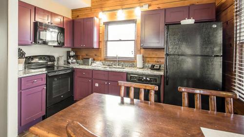 a kitchen with purple cabinets and a black refrigerator at Bluegreen Vacations Christmas Mountain Village, an Ascend Resort in Wisconsin Dells