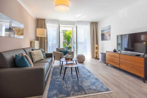 uma sala de estar com um sofá e uma televisão em Villa Strandidyll FeWo pier25 N 1 em Binz