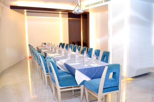 a long table with blue chairs in a room at Hotel Park Residency in New Delhi