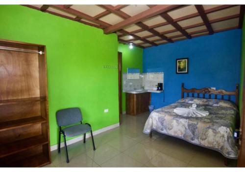 a bedroom with a bed and a green wall at Cabinas Los Tucanes Private Room #4 with Volcano view in Fortuna