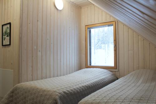 a bedroom with a bed and a window at Hiekkaranta Holiday Home in Parikkala