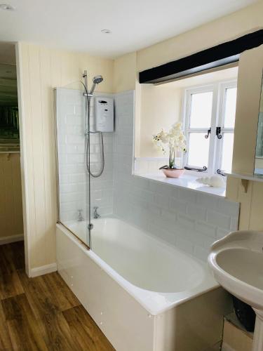 a bathroom with a bath tub and a sink at The Royal Oak Inn in Withypool