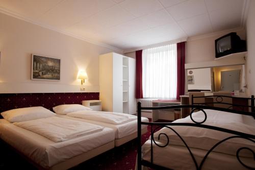 a hotel room with two beds and a mirror at Pension Pharmador in Vienna