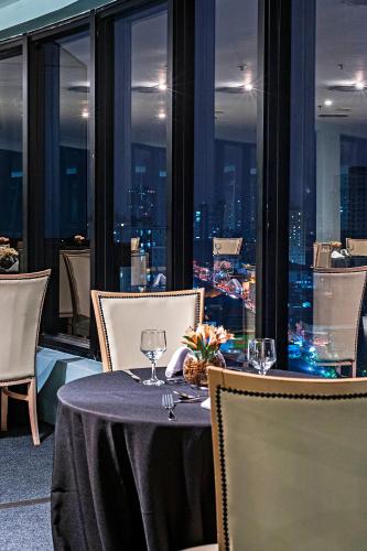 a table and chairs with a view of a city at Slaviero Guarulhos Aeroporto in Guarulhos
