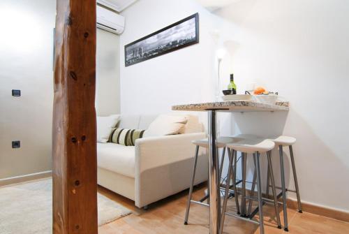 sala de estar con sofá blanco y bar en MIT House Genova en Madrid, en Madrid