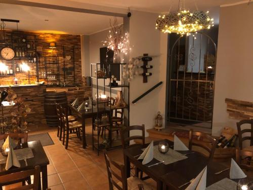 a restaurant with tables and chairs and a chandelier at Pension Mühlhahn in Schierke