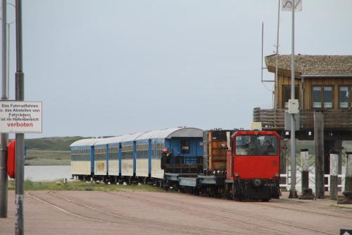 a train on the tracks next to a building at Ferienhaus Strandhafer in Wangerooge