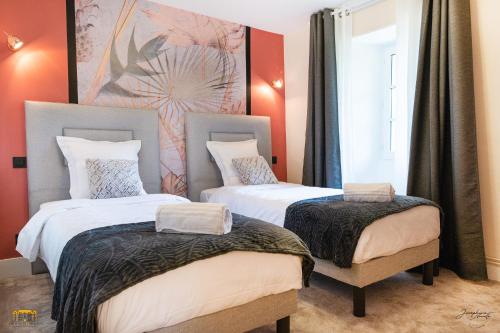 two twin beds in a room with red walls at Château d'Hermival in Hermival-les-Vaux