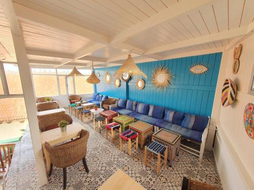 a living room with a blue couch and tables and chairs at Art house in El Jadida